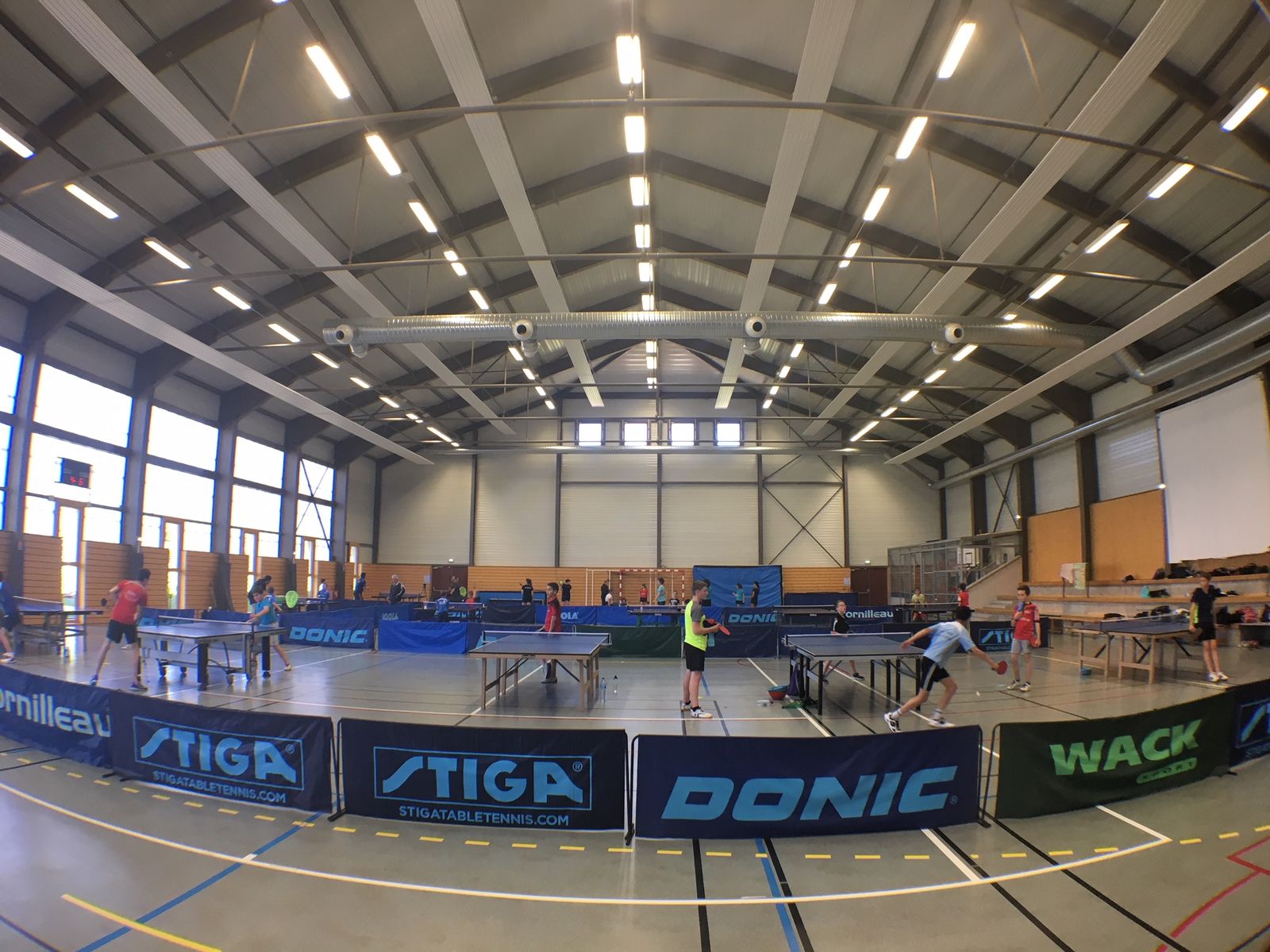 Les joueurs du club réunis autour des tables au gymnase